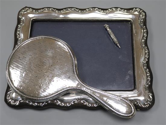A modern silver mounted photograph frame, a silver mounted hand mirror and a white metal propelling pencil.